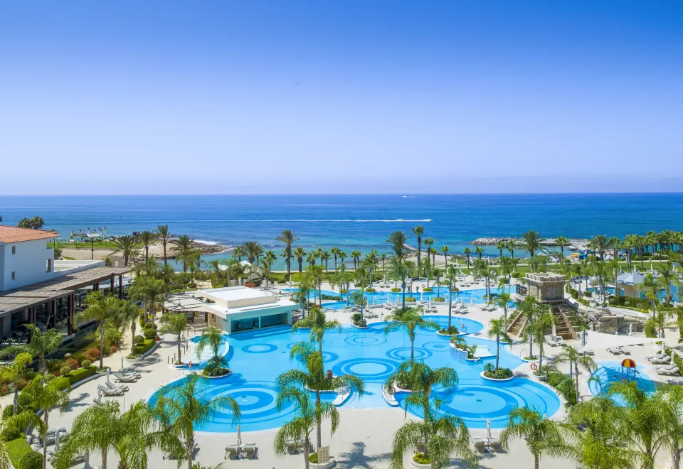 a pool with palm trees and a body of water